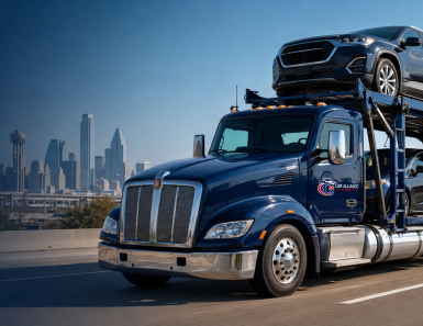 A blue car carrier truck, specializing in Auto Transport Dallas TX, transports multiple vehicles on a highway with a city skyline in the background under a clear blue sky.